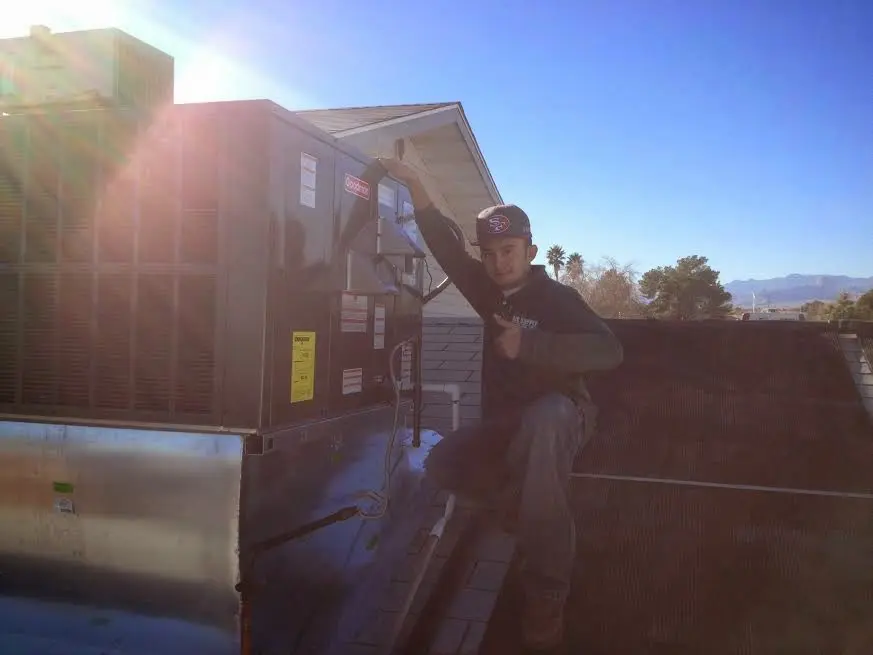 HVAC technician performing Air Duct Repair on a rooftop unit in Crystal